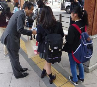写真：金田一学長予定者が、高校生へ県立大学説明会の街頭PRをしている