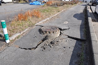 写真：隆起したマンホール