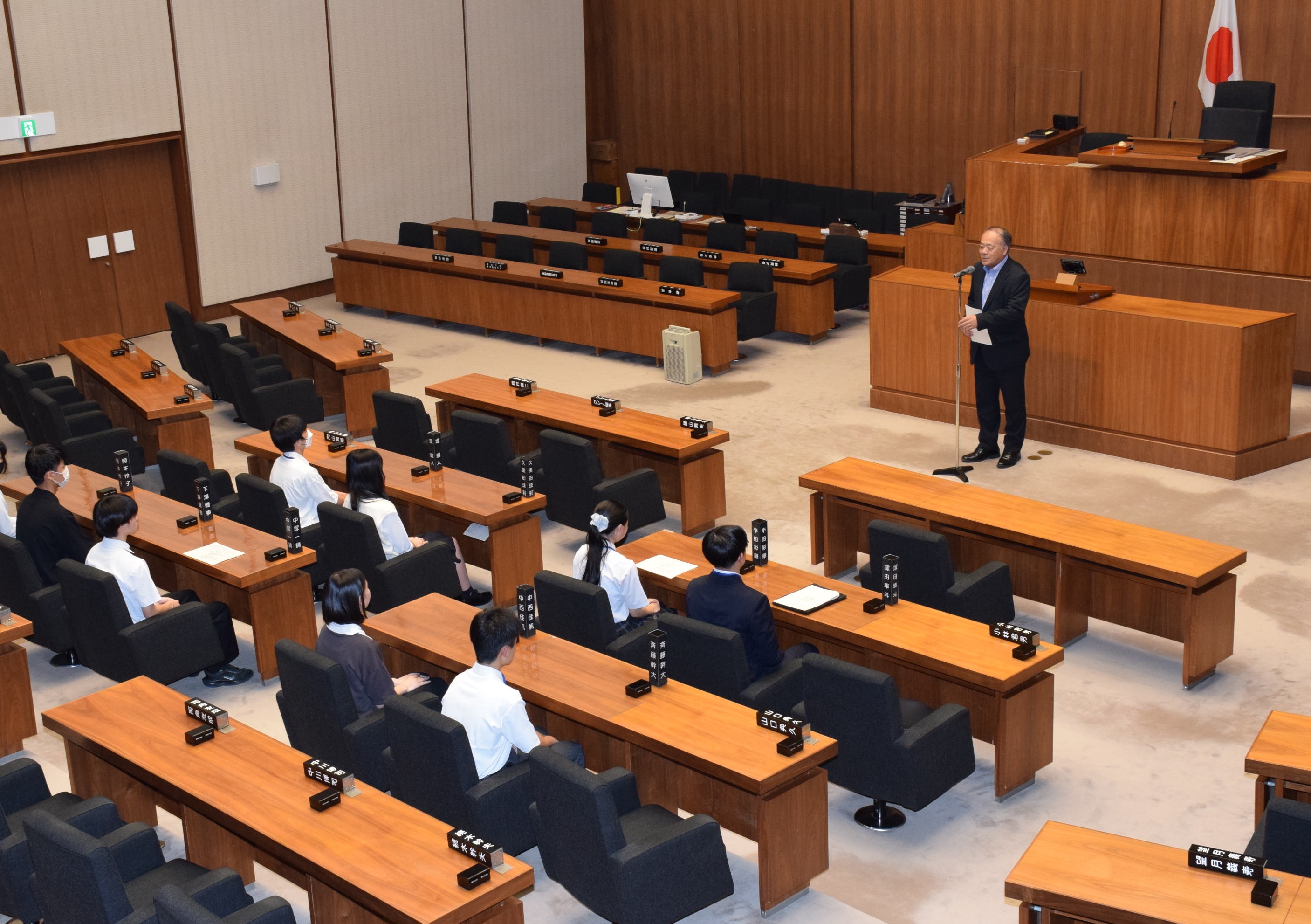 議場で議長が入賞した高校生にお祝いのあいさつをする様子