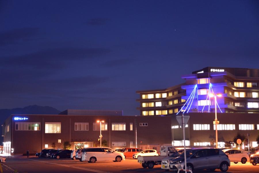 青い光でライトアップされた伊那中央病院の建物