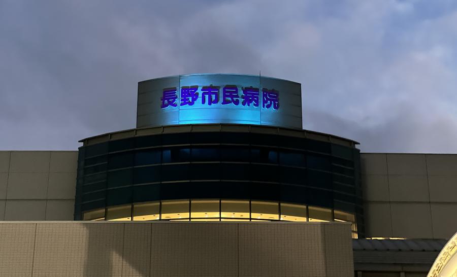青い光でライトアップされた長野市民病院の建物