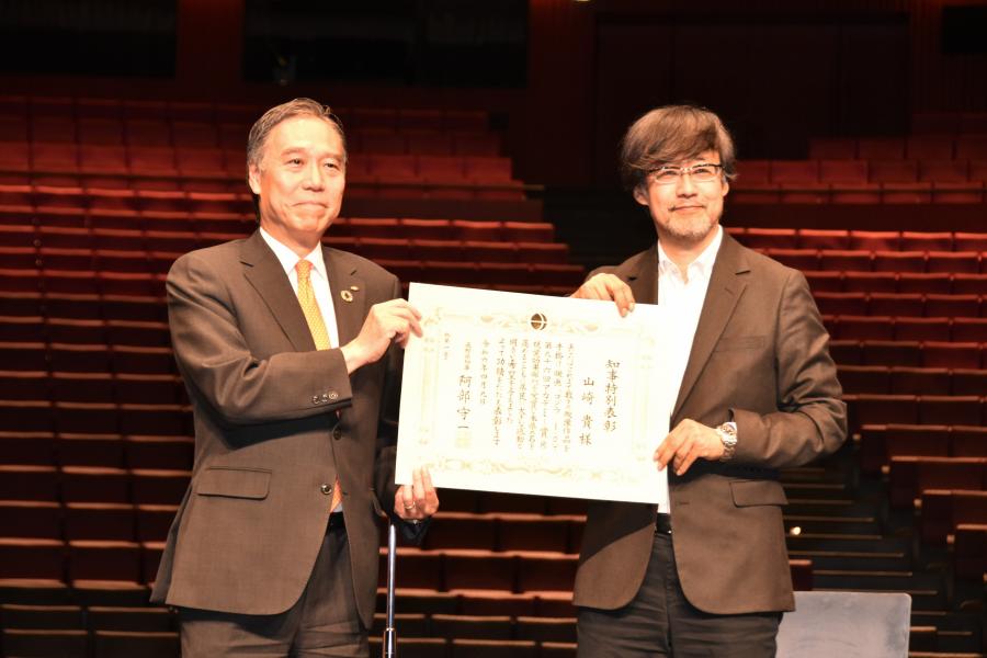 表彰状を持って記念撮影する知事と監督