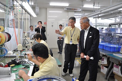 写真：基盤の実装を視察する村井知事