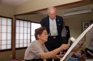 写真：菅沼さんの作業の様子を拝見する村井知事