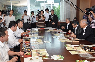 写真：藤木シェフから弁当の説明を受ける村井知事