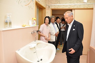写真：助産師の方から分娩室の設備について説明を聞く村井知事