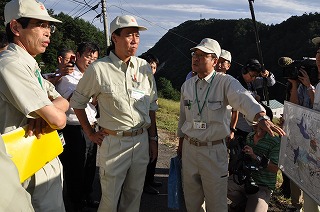 写真：職員から進ちょく状況を聞く阿部知事