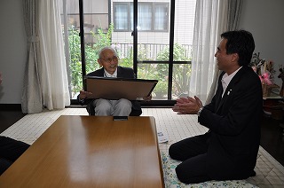 写真：太田さんにお祝い状を渡す阿部知事