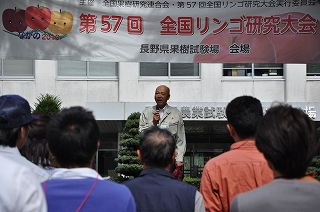 写真：視察に訪れたリンゴ生産者にあいさつをする飯島県果樹試験場長