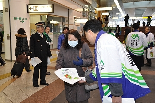 写真：駅利用者に観光パンフレットを配布する様子
