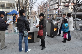 写真：ペレットストーブについて説明を受ける参加者