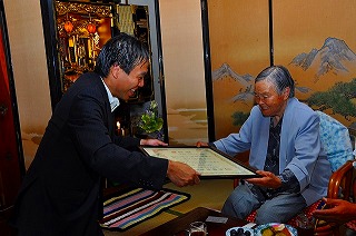 写真：上原ます子さんにお祝いを伝える知事