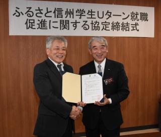写真：協定書をもって握手をしている太田副知事と日本福祉大学の方