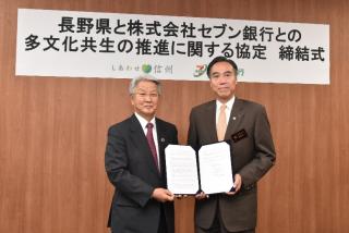 写真：報道陣に協定書を披露する株式会社セブン銀行の二子石会長と知事