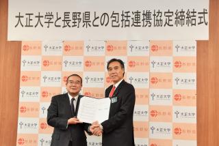 写真：報道陣に協定書を披露する大正大学の大塚学長と知事