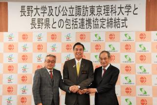写真：知事を中央に長野大学学長（向かって左）と公立諏訪東京理科大学学長（向かって右）の3者が握手を交わす場面