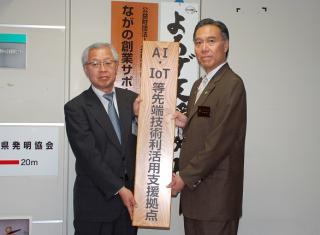 阿部知事がAI・IoT等先端技術利活用支援拠点の看板をもっているところ