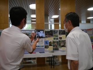 沖縄企画展示の前で沖縄県の人と話している様子