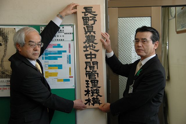 写真：長野県農地中間管理機構の発足し、執務室の入口へ看板を掲示している様子