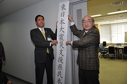 写真：「東日本大震災支援県民本部」の看板を持った知事ら