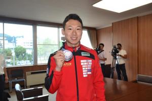 写真：銀メダルを持って記念撮影する西藤選手