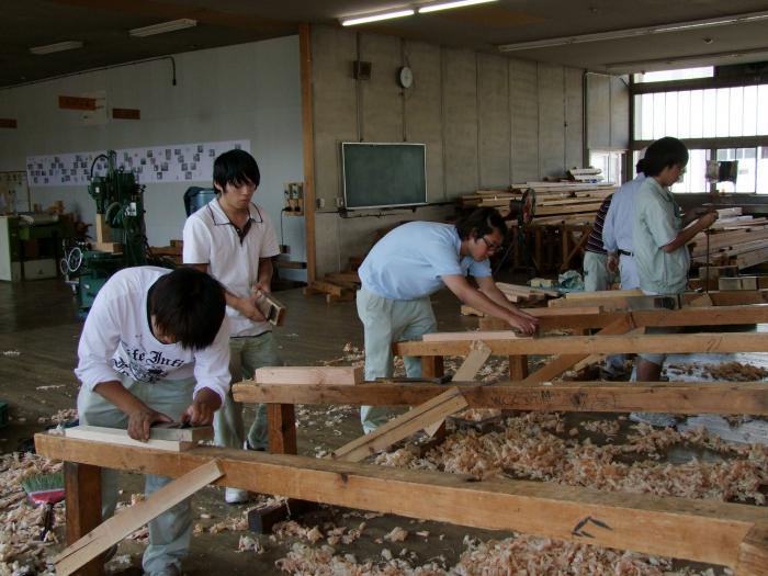 鉋を使い木を削る作業中